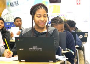 female student smiles while looking at laptop